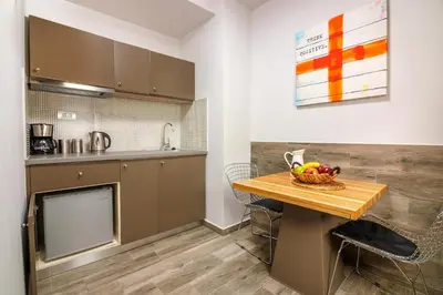 a kitchen with a table with a bowl of fruit on it at Rigas City Apartment (BLUE) in Chania Town