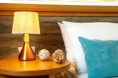 a lamp on a table next to a bed at Rigas City Apartment (BLUE) in Chania Town