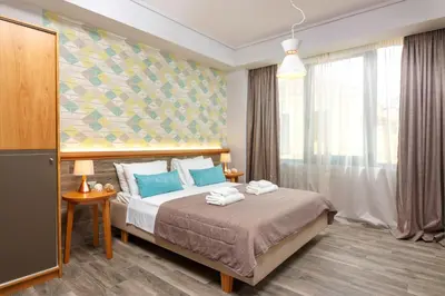 a bedroom with a bed and a large window at Rigas City Apartment (BLUE) in Chania Town