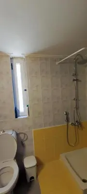 a bathroom with a toilet and a shower with a window at Top Holidays Apartments in Chania Town
