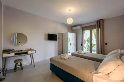 a bedroom with a bed and a desk and a mirror at Villa Vasiliki in Stalos