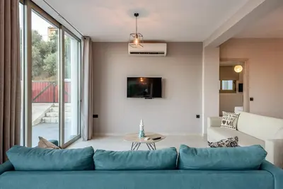 a living room with a blue couch and a table at Villa Vasiliki in Stalos