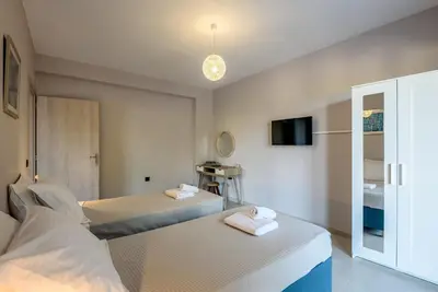a hotel room with two beds and a tv at Villa Vasiliki in Stalos