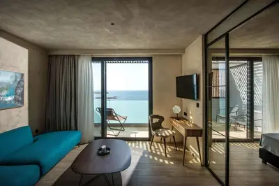 a living room with a blue couch and a view of the ocean at Chania Flair Boutique Hotel, Adults only, Tapestry Collection by Hilton in Chania Town