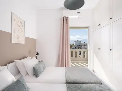 a white bedroom with a bed and a window at Villa Kelaidis in Megála Khoráfia
