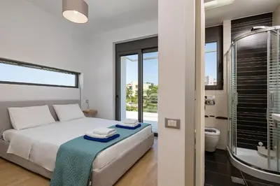 a bedroom with a bed and a bathroom with a shower at Villa Darazzo with Private Pool in Daratso