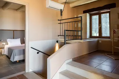 a staircase leading to a bedroom with a bed at Prinus Country Retreat Apokoronas, heated pool, 13km from the sea in Embrósneros