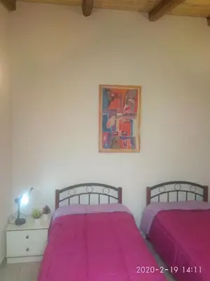 two beds in a bedroom with pink sheets at Spartis House 30m from the beach in Chania Town