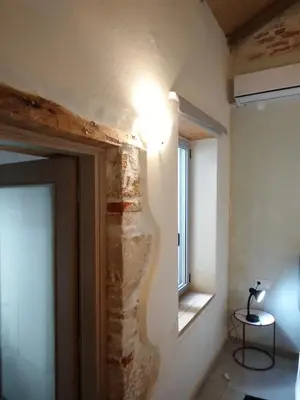 a room with a stone wall and a window at Spartis House 30m from the beach in Chania Town