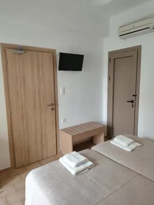 a room with two beds and a door with towels at Protopapas in Palaiochóra