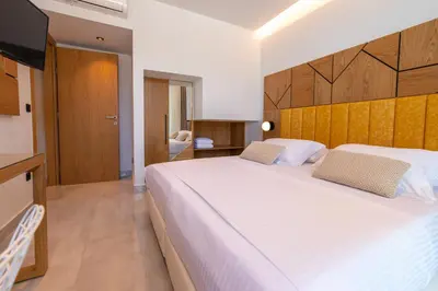 a bedroom with a large white bed and a television at Villa Lydia I Superb views, two pools, next to the city in Kissamos