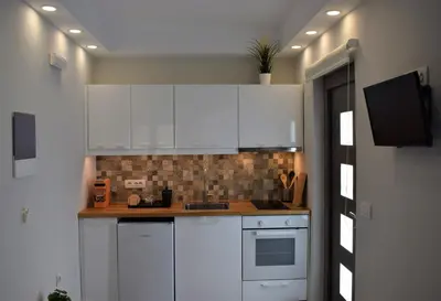 a white kitchen with white cabinets and a sink at Antigonis Garden House in Chania Town