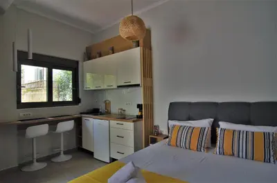 a bedroom with a bed and a desk and a kitchen at Antigonis Garden House in Chania Town