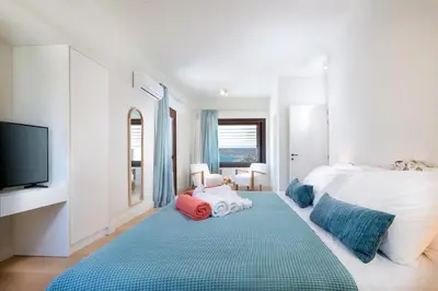 a bedroom with a large bed and a tv at Kassiopeia Villa in Chania Town
