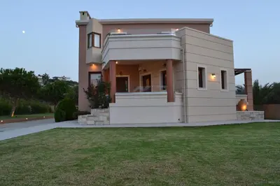 a house with a lawn in front of it at Ar & Al Luxury Villa in Galatás