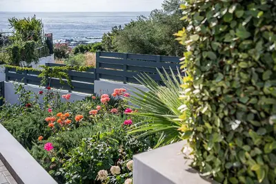 a garden with flowers and a blue bench at Sunset Elafonisi Apartments in Livadia