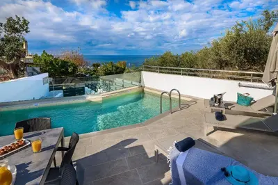 a swimming pool with a view of the ocean at Sunset Elafonisi Apartments in Livadia