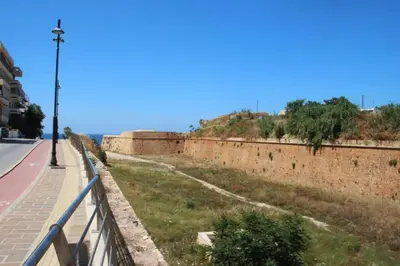 an old brick wall next to a road at Daphne's house Families Only in Chania Town