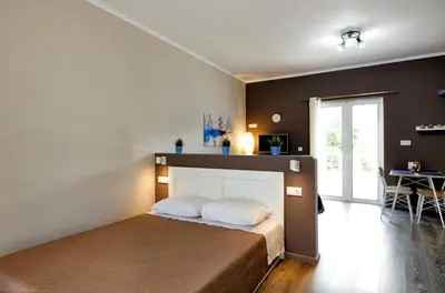 a bedroom with a bed in a room with a table at Maria's modern studio 5min from beach in Souda