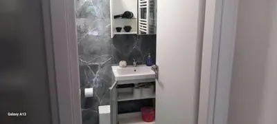 a bathroom with a sink and a marble wall at GIANNIS in Galatás