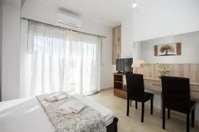 a bedroom with a bed and a desk with two chairs at Aqua Marine in Falasarna