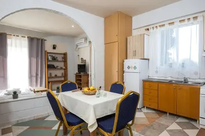 a kitchen with a table with chairs and a white refrigerator at Aqua Marine in Falasarna
