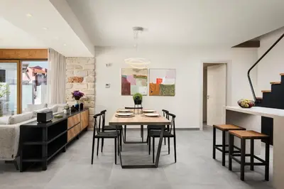 a dining room and living room with a table and chairs at Amaré Chania Luxury Residence in Stérnai