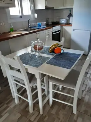 a kitchen with a white table and chairs at The Prickly Pear Apartment in Chania Town