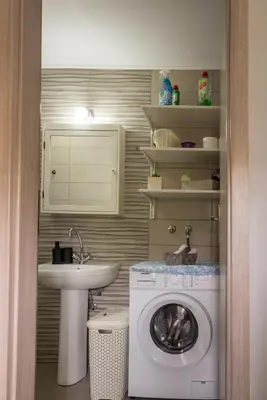 a bathroom with a washing machine and a sink at The Prickly Pear Apartment in Chania Town