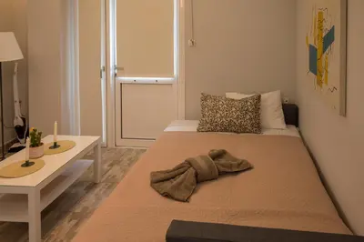 a bedroom with a bed and a table with a blanket at The Prickly Pear Apartment in Chania Town