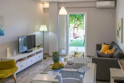 a living room with a couch and a tv at The Prickly Pear Apartment in Chania Town