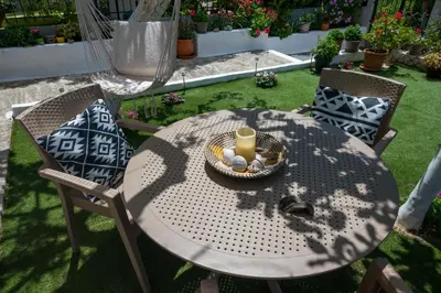 a table and chairs with a candle on a lawn at The Prickly Pear Apartment in Chania Town