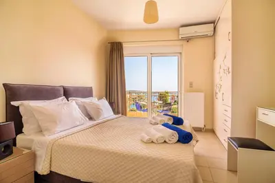 a bedroom with a bed with a large window at Crete View in Marathi