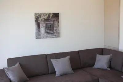 a couch in a room with a picture on the wall at Crete View in Marathi