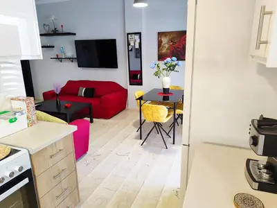a kitchen and living room with a red couch at Marlen House Chania in Chania Town