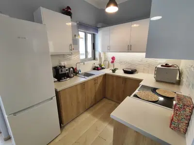 a kitchen with a white refrigerator and wooden cabinets at Marlen House Chania in Chania Town