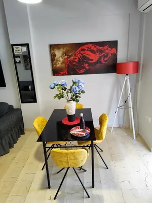 a dining room with a table and chairs and a painting at Marlen House Chania in Chania Town