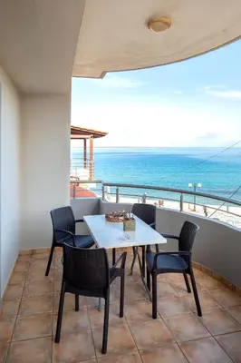 a table and chairs on a balcony with the ocean at Captain Nick in Chania Town
