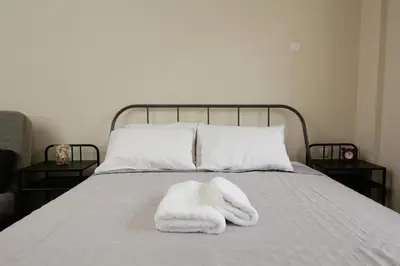 a bed with a pile of white towels on it at Captain Nick in Chania Town