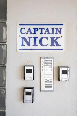 a sign for a carlin nick hanging on a wall at Captain Nick in Chania Town