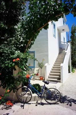 a blue bike parked next to a house with stairs at Anthea Apartments in Palaiochóra