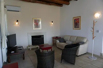 a living room with a couch and a tv at Kukuwaia in Almirida