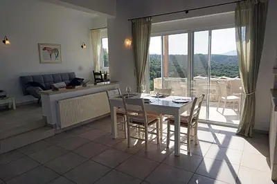a living room with a table and chairs and a couch at Kukuwaia in Almirida