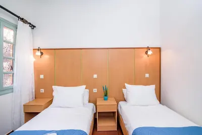 a room with two beds and a window at Alegria Pension in Chania Town