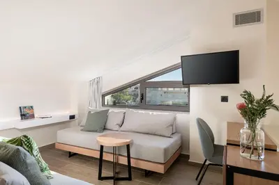 a living room with a couch and a table at Mossa Well Being Hotel - Heated pool and Wellness Spa in Kato Daratso