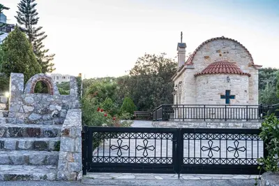 a church with a gate in front of a building at Almyrida Village & Waterpark in Almirida