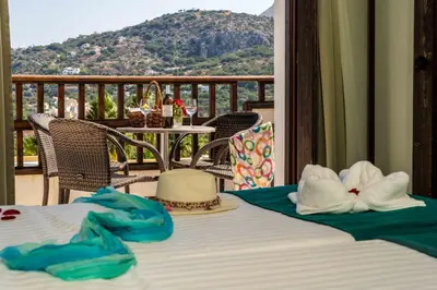 a table with hats and towels on top of a balcony at Almyrida Village & Waterpark in Almirida