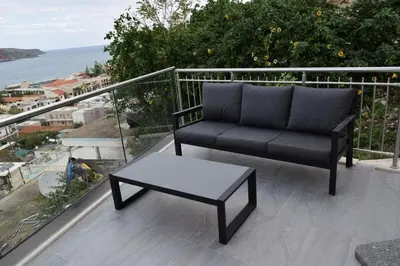 a couch and a coffee table on a balcony at Platania's Horizon in Plataniás