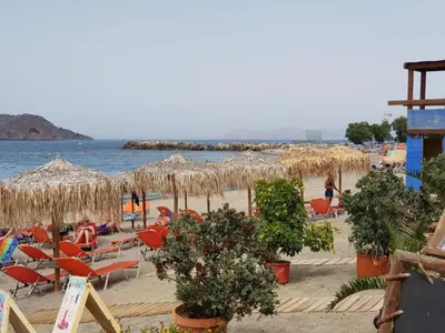 a beach with chairs and umbrellas and the water at Platania's Horizon in Plataniás