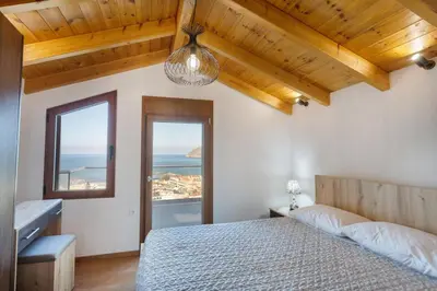 a bedroom with a bed and a view of the ocean at Platania's Horizon in Plataniás